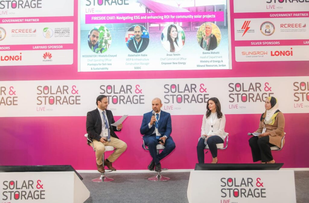 Four speakers participating in a panel discussion on stage at a Solar and Storage Live exhibition.