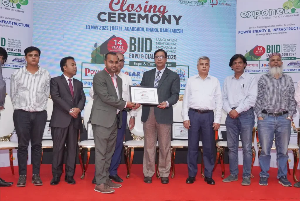 Two corporate professionals holding a framed certificate on a red carpet stage at BIID Expo 2025.