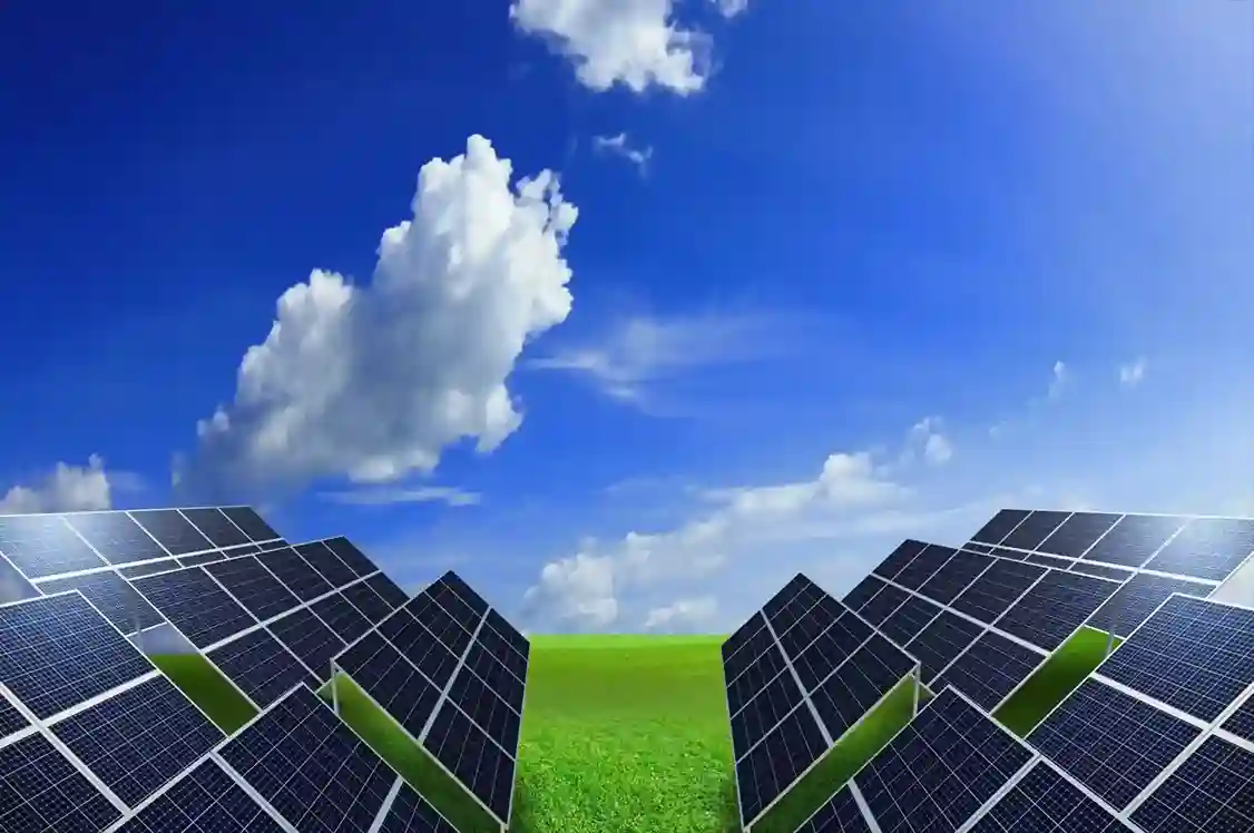 Extensive field of large blue solar panels under a bright blue sky with white clouds.